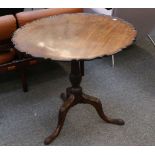 A George III mahogany pie crust tripod table, on reeded column support and carved cabriole legs,