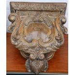 An early 19th Century Italian carved walnut wall bracket of scroll cartouche form, 45cm high.