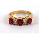 A ruby and diamond five stone ring, claw set in a 14ct yellow gold band.