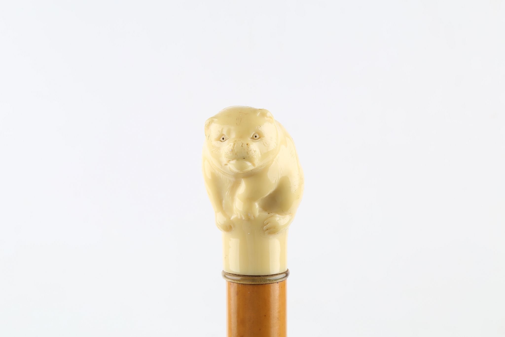 AN EARLY 20TH CENTURY WALKING CANE WITH EARLY CELLULOID HANDLE, in the form of a bear, mounted on