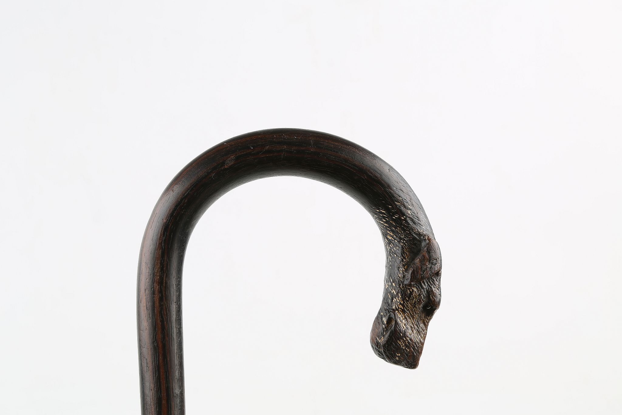 A CROOK HANDLED ROSEWOOD WALKING STICK, with a dog head terminal with glass eyes, 33 inches (84cm).