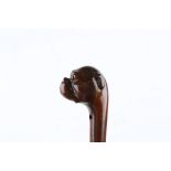 A ONE PIECE FOLK ART CANE, bulldog handle with glass eyes, 34 inches (87cm).