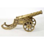 A MID 19th CENTURY STYLE CAST BRASS DESKTOP CANNON, on a decorative c-form gun - carriage with front