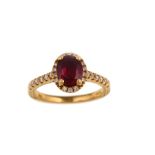 A gold, ruby and diamond cluster ring The oval-cut ruby, in a four-claw setting, within a surround