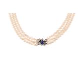 A triple-strand cultured pearl necklace with a sapphire and diamond clasp The rows of 5.3 - 5.8mm