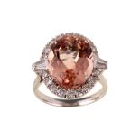 A morganite and diamond cluster ring The oval-cut morganite, in a four-claw setting, within a
