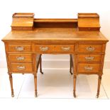 An Edwardian oak Carlton House style writing desk, having three short drawers to each side and a