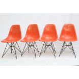 CHARLES EAMES FOR HERMAN MILLER, a set of four 1950s orange fibreglass shell chairs on black