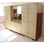 A 1950s ITALIAN PARCHMENT TRIPLE WARDROBE, the central section with mirrored double cupboard over