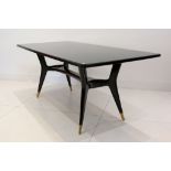 A 1950s ITALIAN DINING TABLE, with black glass inset top, on mahogany and walnut base, the legs