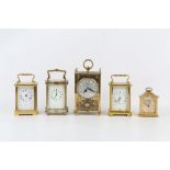 AN EARLY 20TH CENTURY ENGLISH SILVERED BRASS CARRIAGE CLOCK TOGETHER WITH FOUR OTHER BRASS CLOCKS