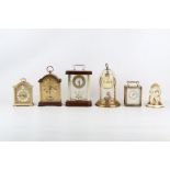 A SWISS LACQUERED BRASS GEORGE III STYLE ALARM CLOCK TOGETHER WITH FIVE FURTHER BRASS CASED CLOCKS