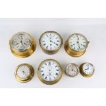 SEVEN VARIOUS BRASS BULKHEAD SHIPS CLOCKS including an example signed 'A.R.A HENRY HUGHES & SONS