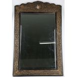 A large carved Indian wall mirror, with gold painted foliate decoration and inset glaze portrait