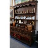 An 18th Century style, oak dresser with boarded plate rack, the pot board base fitted with three