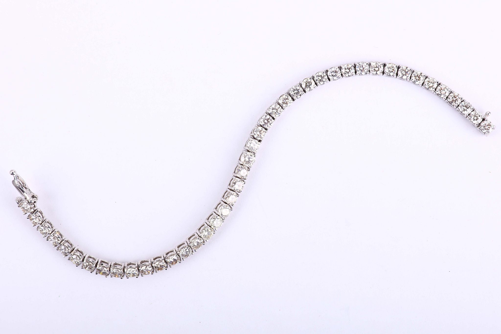 A diamond line bracelet, The line of brilliant-cut diamonds, highlighted centrally by a slightly