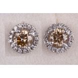 A pair of coloured diamond and diamond earstuds, Each brilliant-cut diamond of brown tint,