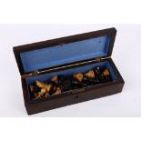 An early 20th Century boxwood and ebony carved chess set, complete, in mahogany presentation box,
