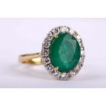 An emerald and diamond cluster ring, The oval-cut emerald, within a brilliant-cut diamond