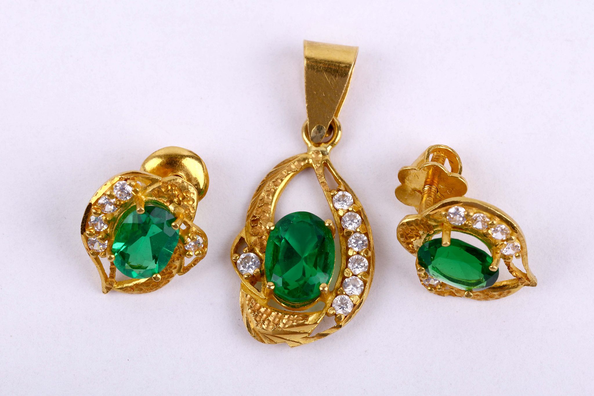 A 22 carat gold, synthetic emerald and imitation diamond pendant and earring suite, UK hallmarks,