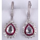 A pair of ruby and diamond pendent earrings, Each pear-shaped rose-cut diamond, within a surround of