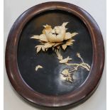 An early 20th Century Japanese oval black lacquer and bone panel, decorated with birds and peony