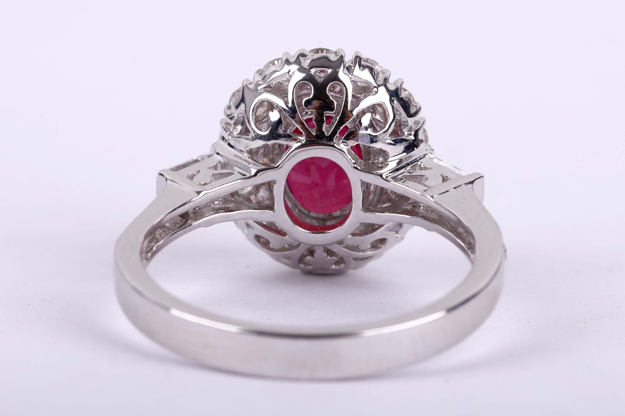 A glass filed ruby and diamond ring, The oval-cut glass filled ruby, within a surround of - Image 2 of 2