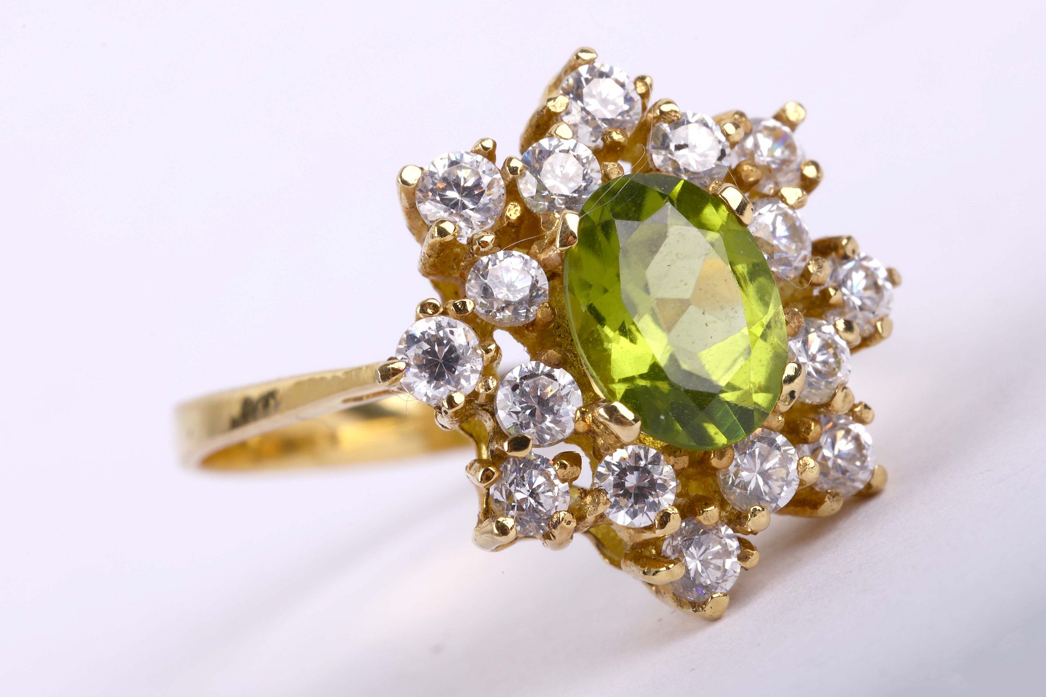 A peridot cluster ring              The oval-cut peridot, within a cluster of brilliant-cut cubic