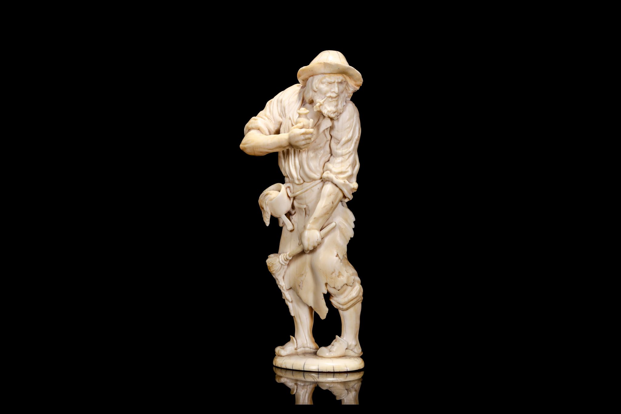 AN 18TH CENTURY GERMAN IVORY FIGURE OF A PAINTER the standing figure in ragged clothes and hat,