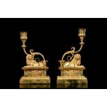 A PAIR OF 19TH CENTURY FRENCH GILT BRONZE CANDLESTICKS MODELLED WITH LIONS each with a single upward