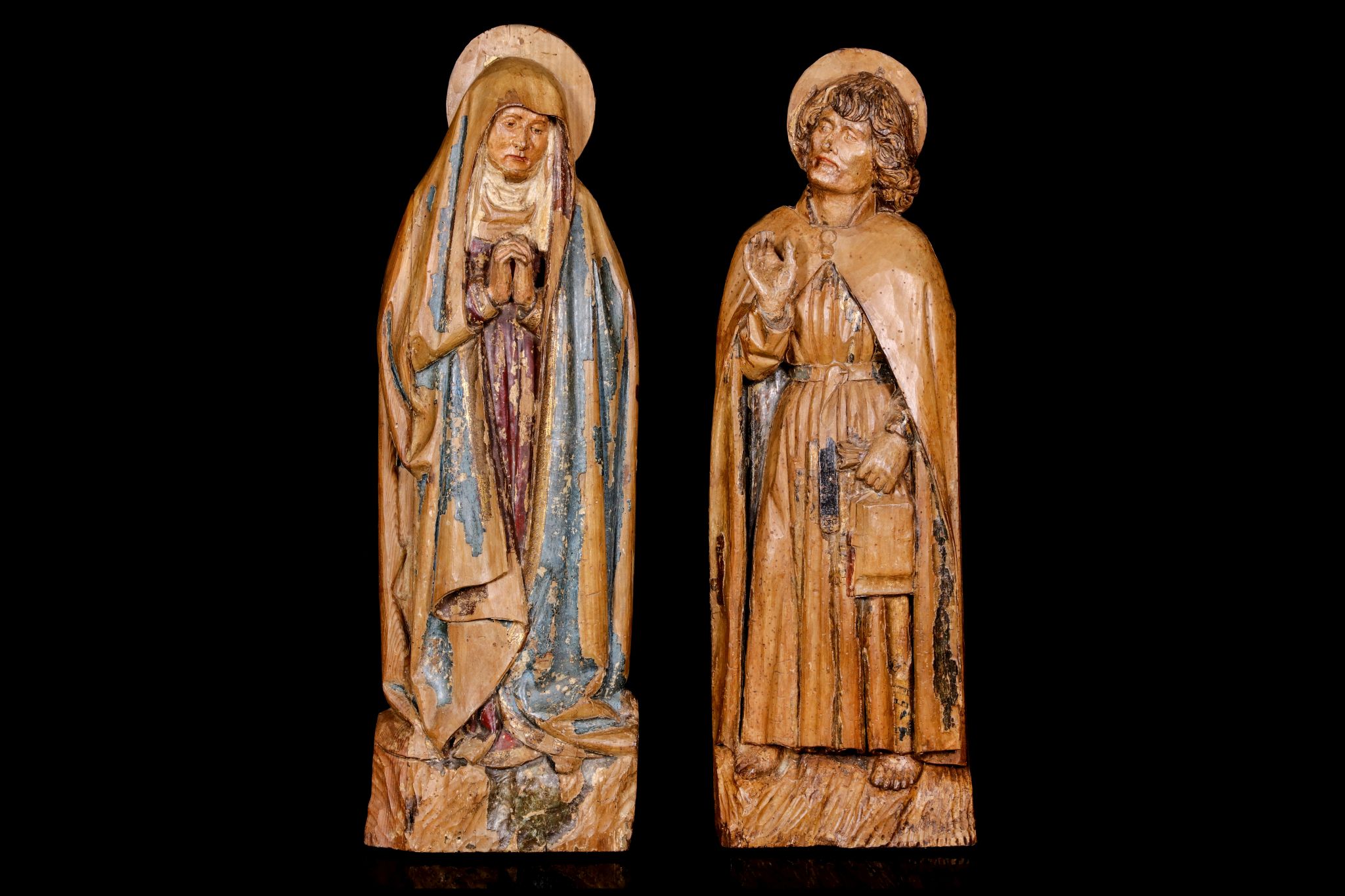 A PAIR OF EARLY 16TH CENTURY GERMAN (FRANCONIAN) CARVED AND POLYCHROME DECORATED LIMEWOOD FIGURES OF