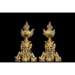 A PAIR OF 19TH CENTURY FRENCH GILT BRONZE FIRE DOGS in the Rococo style, surmounted by floral urns