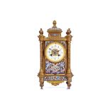 A LATE 19TH CENTURY FRENCH GILT BRONZE AND CHAMPLEVE ENAMEL MANTEL CLOCK surmounted by a pad top and