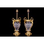 A PAIR OF 19TH CENTURY EMPIRE STYLE GLASS AND GILT BRONZE LAMP BASES of baluster form, with putti