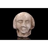 A CARVED STONE HEAD OF A WOMAN, PROBABLY MEDIEVAL an architectural fragment, with flat back, 19cm