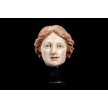 AN ITALIAN 17TH CENTURY CARVED WOOD AND POLYCHROME DECORATED HEAD OF A WOMAN raised on a later