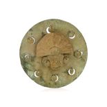 A PRE-COLUMBIAN-STYLE BRONZE PLAQUE The round plaque with a central applique of a head wearing large