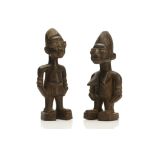 TWO WOODEN IBEJI FIGURES, NIGERIA Each of stylised form, with incised decoration, large eyes and