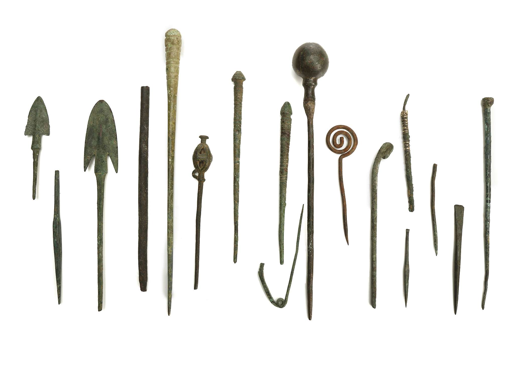 A GROUP OF BRONZE PINS, IMPLEMENTS AND ARROW HEADS Circa 10th Century BC to Roman Period Including a