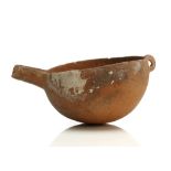 A CYPRIOT SPOUTED BOWL Bronze Age, circa 2300-1600 B.C. A red polished ware terracotta bowl with