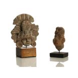 TWO PRE-COLUMBIAN TERRACOTTA HEADS Including one example enlivened with red slip, with large