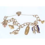 A gold charm bracelet, The 9 carat yellow gold curb-link bracelet, suspending seven charms, UK