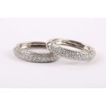 A pair of pave set white gold diamond hinged hoop earrings.