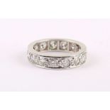 A white gold eternity ring, channel set with circular faceted stones.