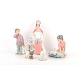 A Lladro porcelain model of a ballerina, a model of a girl holding a hat, a little model of a