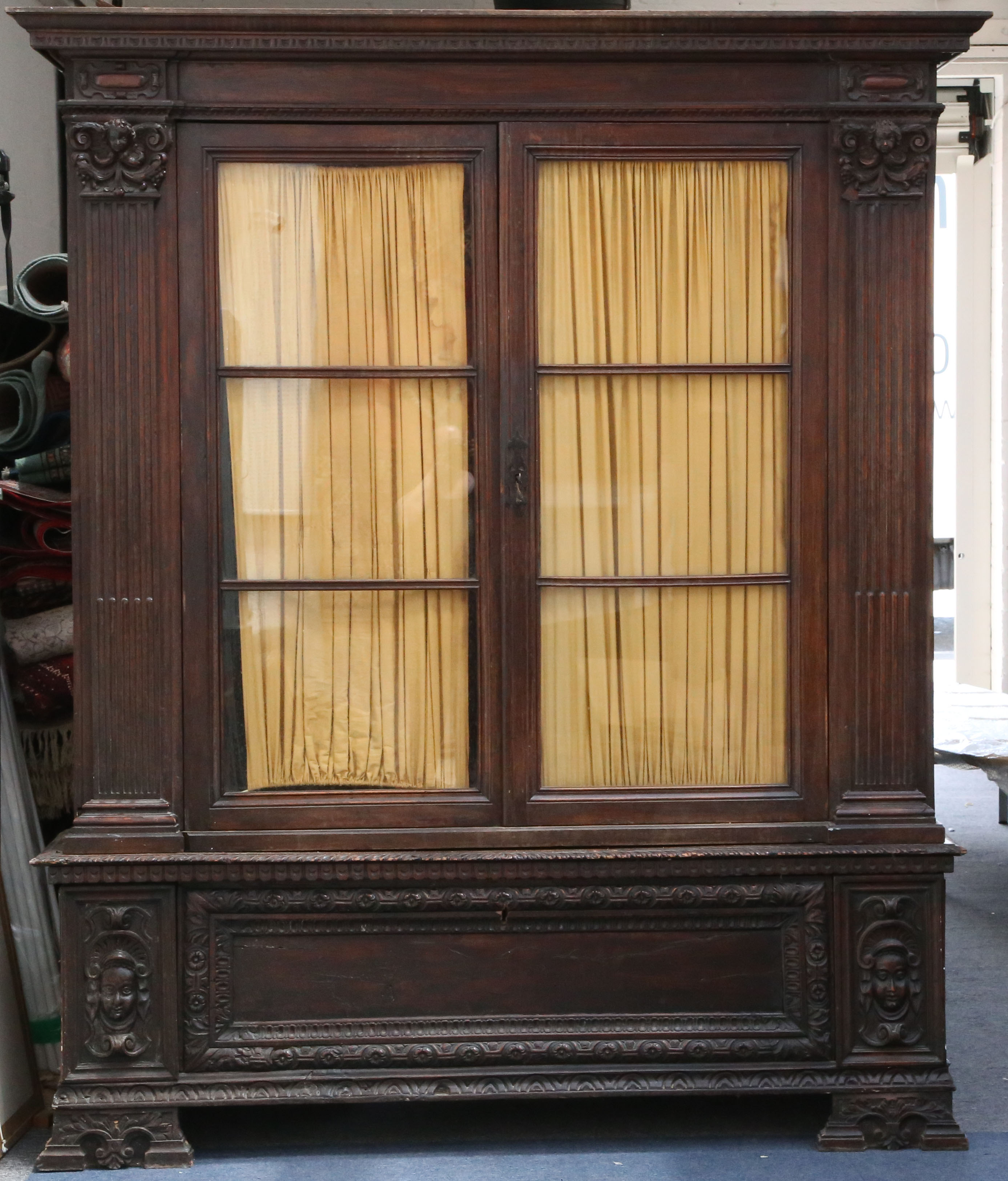An Italian walnut cabinet, the base converted from an 18th Century cassone, the glazed upper section
