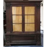 An Italian walnut cabinet, the base converted from an 18th Century cassone, the glazed upper section