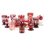 A collection of 13 19th Century and later Bohemian ruby overlaid etched glass beakers.