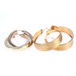 Two pairs of hoop earrings, One of wide brushed design, stamped 18K, the other of silver gilt,