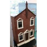 A Victorian dolls house, dated 1889, with a hand-painted red brick facade, the front door with